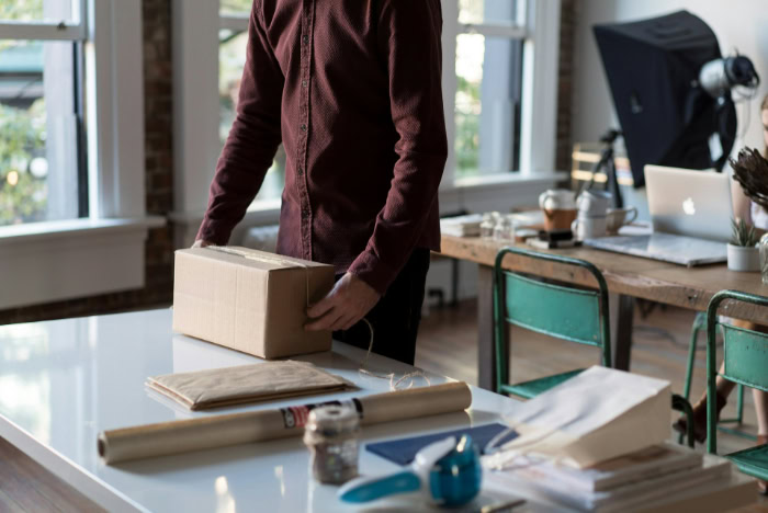 Man preparing cardboard box package for shipment