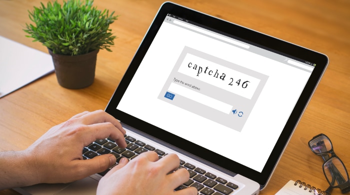 Man typing captcha code on laptop