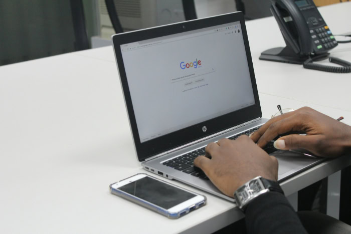 Man typing on HP laptop with Google homepage