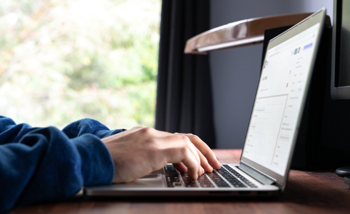 Man typing on silver macbook