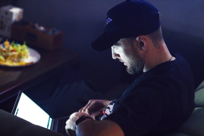 Man using a laptop in a dimly lit room