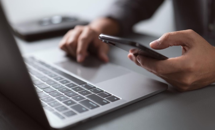 Man using phone and laptop