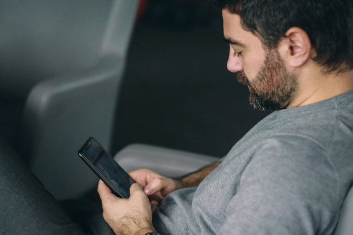 Man using smartphone while relaxing on couch