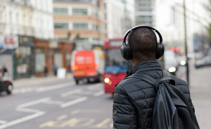 Man wearing noise cancelling headphones on a busy city street