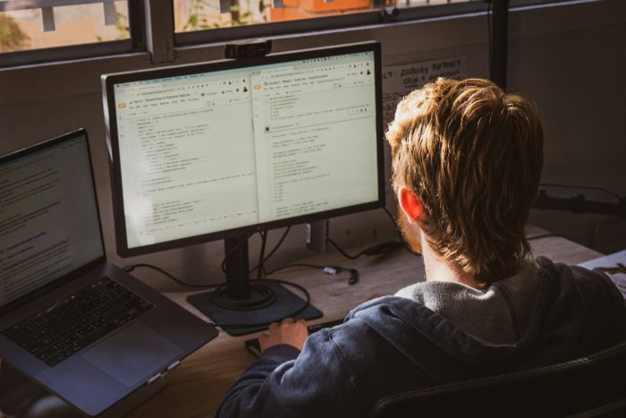 Man working on dual computer monitors at desk