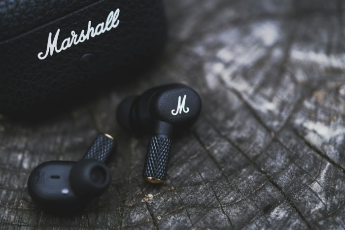 Marshall wireless earbuds on a wooden surface