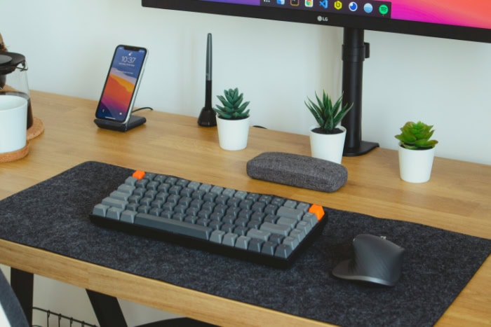 Mechanical keyboard on a modern desk setup with plants