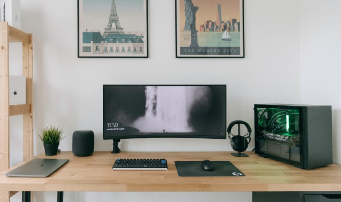 Minimalist desk with ultrawide monitor laptop and visible PC internals
