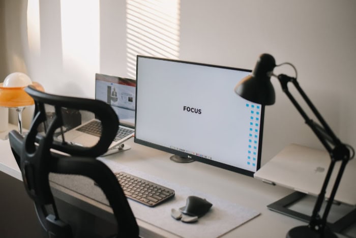 Minimalist workspace with monitor displaying FOCUS