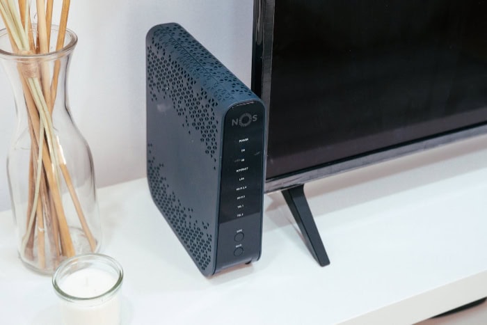 Modern NOS router with LED indicators next to TV