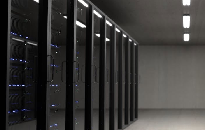 Modern data center with rows of black server racks and blue LEDs