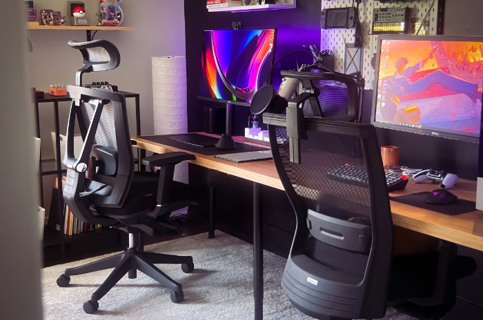 Modern desk setup with mesh office chairs and monitors