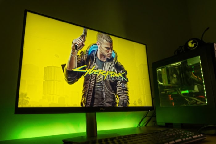 Monitor displaying Cyberpunk 2077 with glowing green lighting