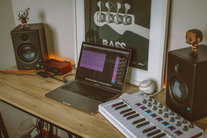 Music production desk with laptop and MIDI keyboard