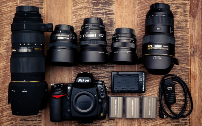 Nikon DSLR and array of lenses arranged on a wooden surface