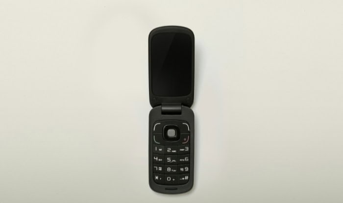 Open black flip phone on a white background