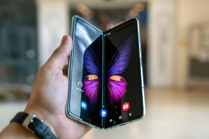 Open foldable phone displaying butterfly themed wallpaper