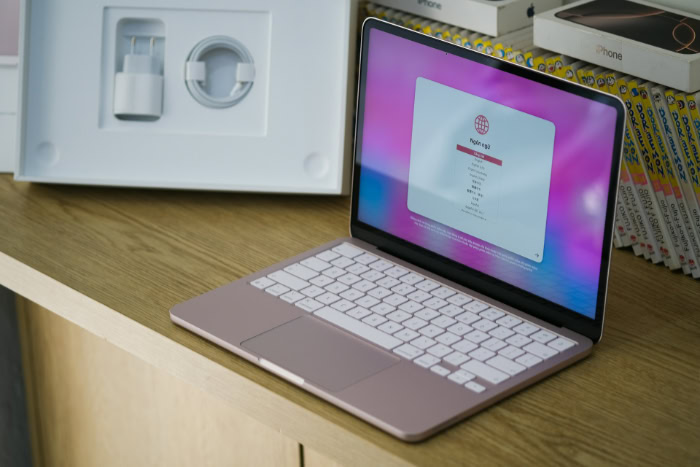 Open pink MacBook Neo with white keyboard