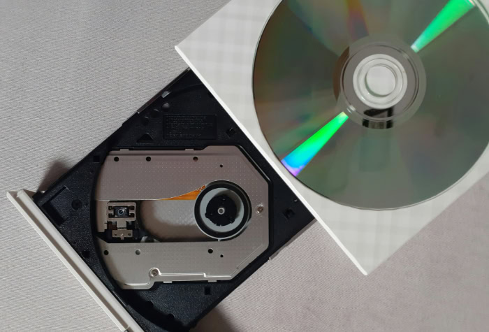 Open white external CD drive with silver disc