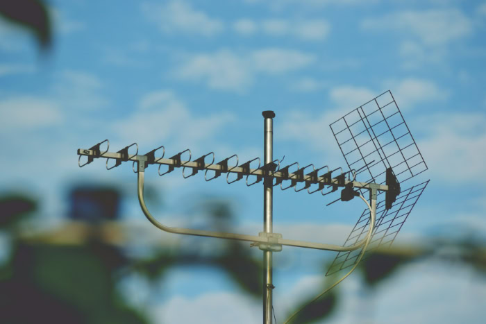 Outdoor television antenna mounted against a blue sky