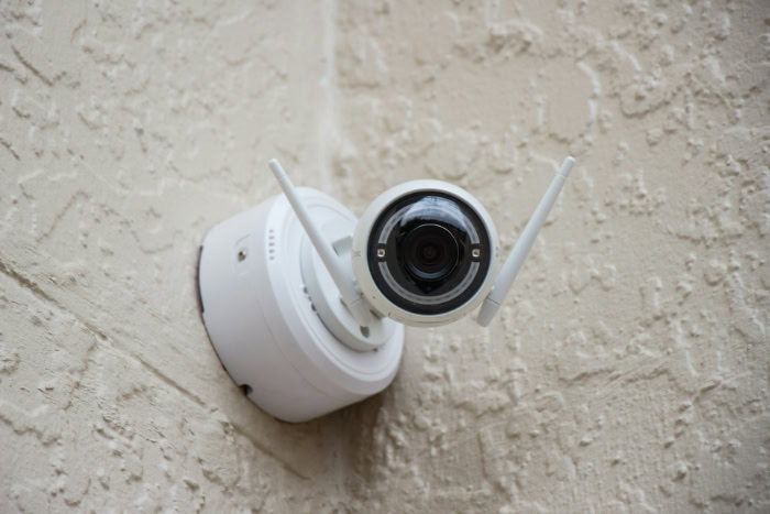 Outdoor wireless security camera mounted on textured wall