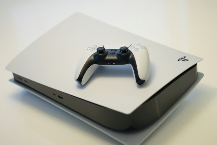 PS5 console with DualSense controller on a white surface