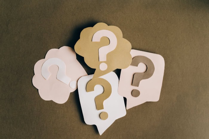 Paper cutouts of question marks in various colors and shapes