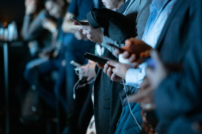 People using smartphones in a crowded indoor setting