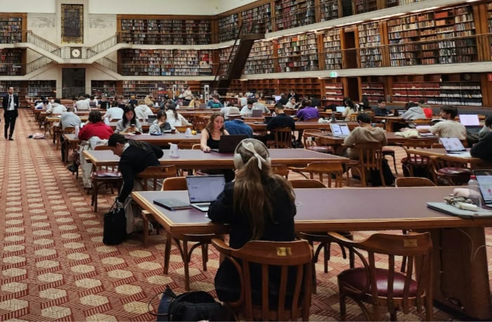 People working on laptops in a large library