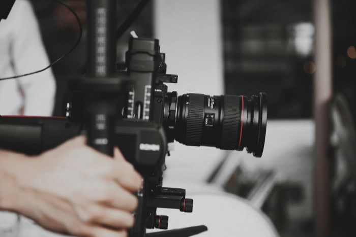 Person adjusting a camera mounted on a gimbal for filming