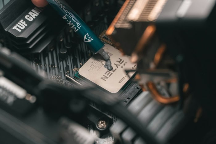 Person applying thermal paste to a Ryzen CPU