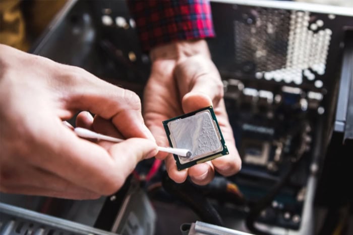 Person cleaning CPU with a cotton swab