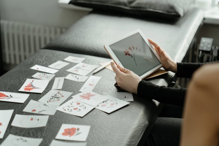 Person designing floral artwork on a tablet