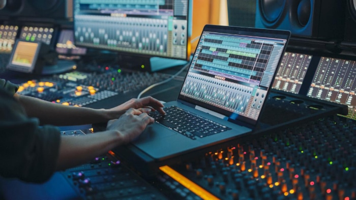 Person editing audio in recording studio