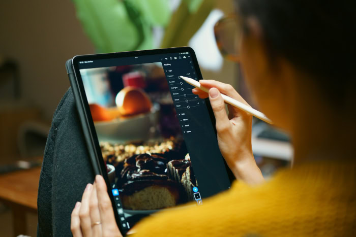 Person editing photo on iPad with Apple Pencil