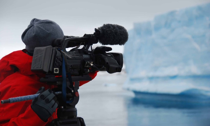 Person filming an iceberg