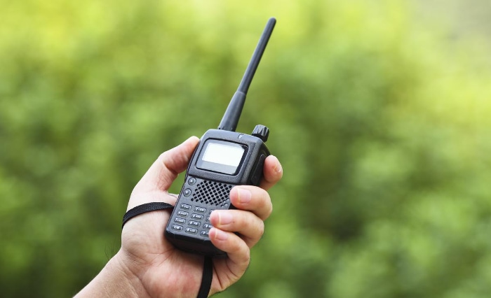 Person holding black walkie talkie