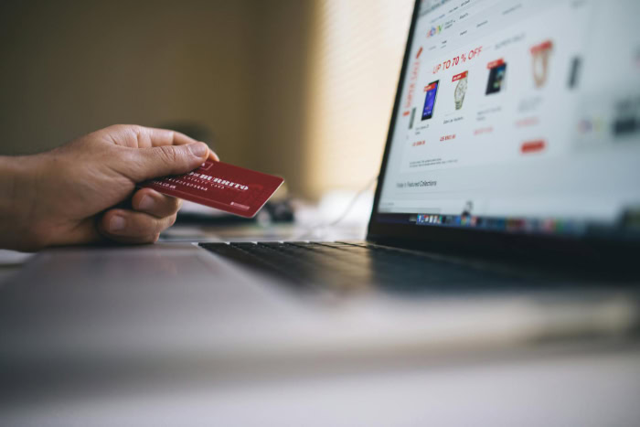 Person holding credit card while shopping online