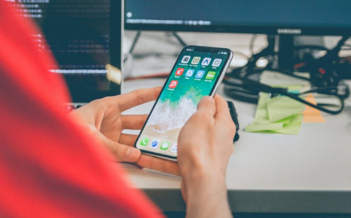 Person holding smartphone with apps visible