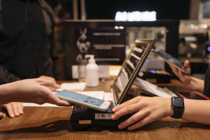 Person making contactless smartphone payment at a terminal
