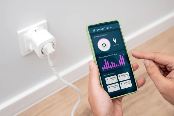 Person monitoring smart plug energy usage on phone
