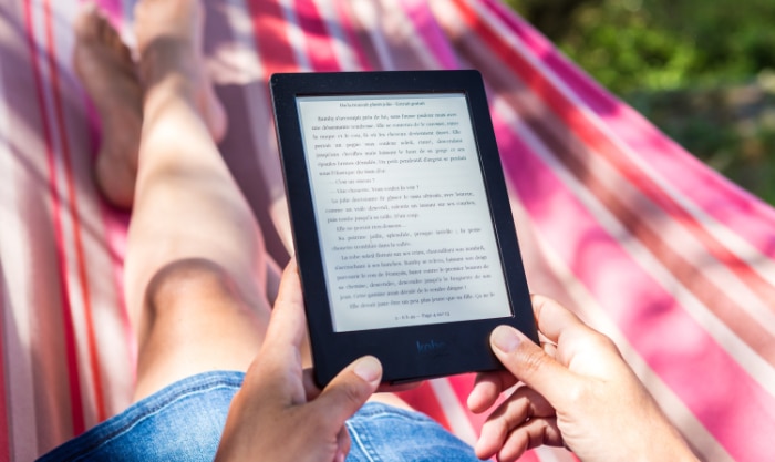 Person on hammock holding kindle