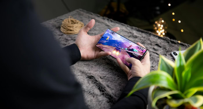 Person playing a racing game on a smartphone