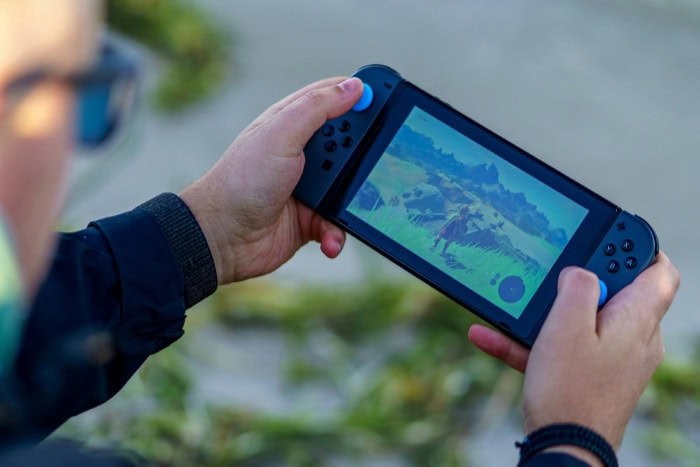 Person playing a video game on a handheld console