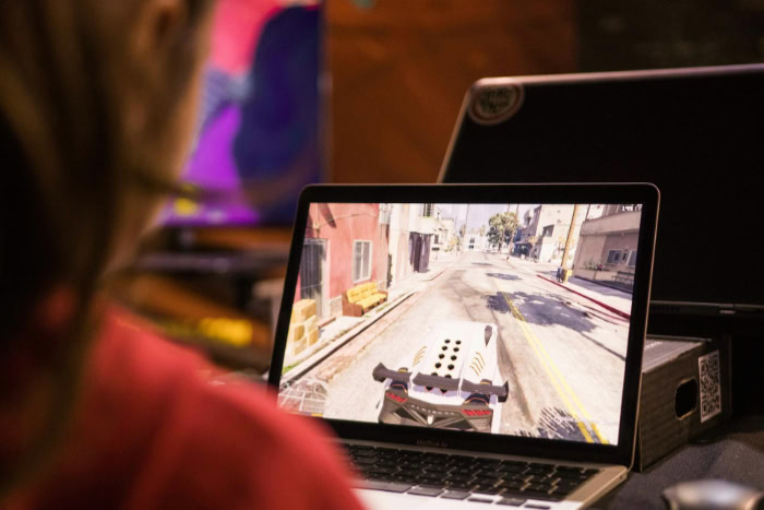 Person playing an open world game on a laptop