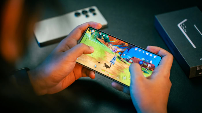 Person playing mobile game on smartphone