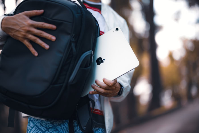 Person putting an iPad Pro into a backpack