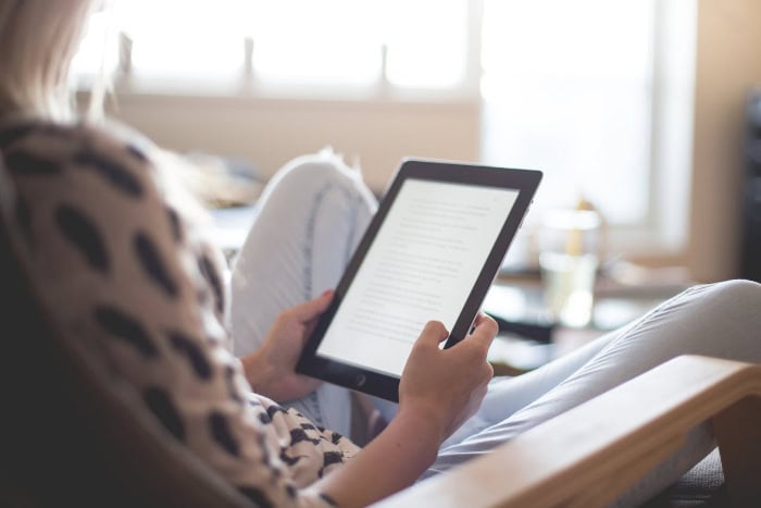 Person reading on an iPad in a relaxed setting