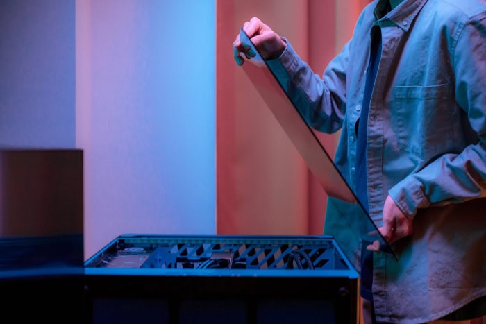 Person removing the side panel of a PC case