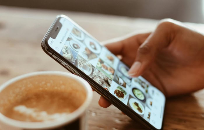 Person scrolling through Instagram food photos on smartphone